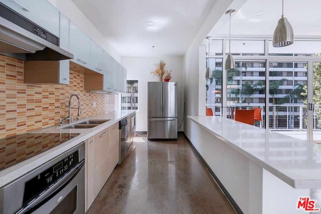 645 West 9th Street, Unit 740 Los Angeles, CA 90015 - Photo 42 of 63 a kitchen with stainless steel appliances granite countertop a lot of counter space and wooden floor