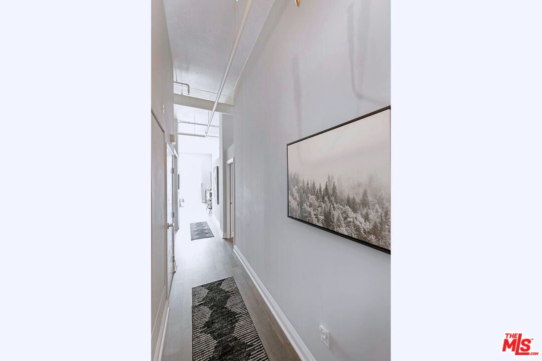 645 West 9th Street, Unit 740 Los Angeles, CA 90015 - Photo 8 of 63 a view of a hallway with paintings on the wall
