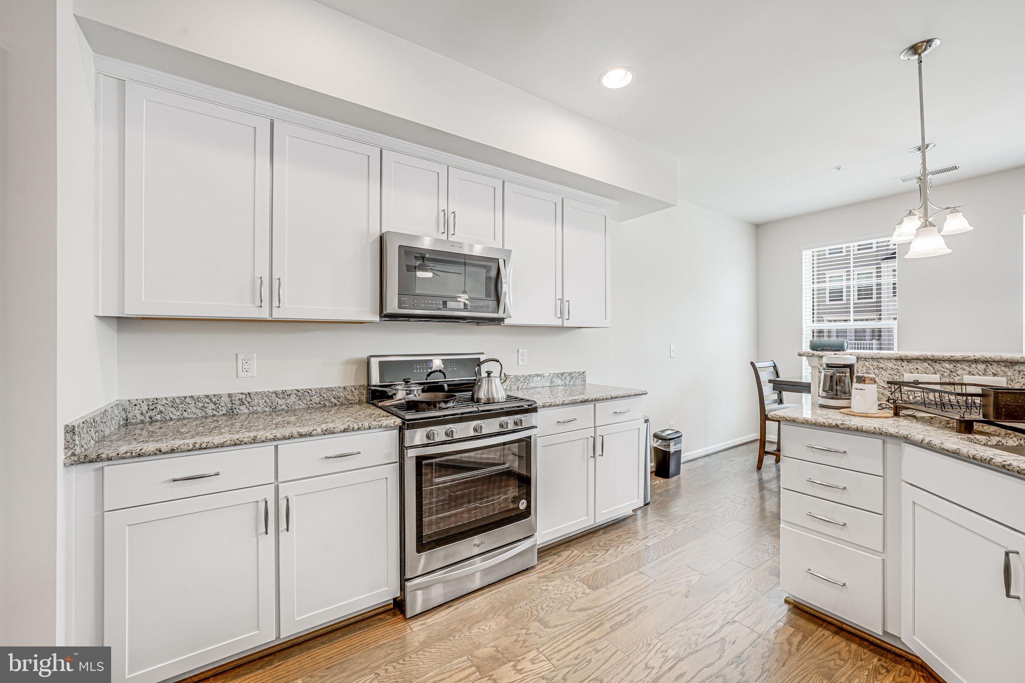 43373 Town Gate Square Chantilly, VA 20152 - Photo 12 of 30 a kitchen with stainless steel appliances granite countertop a sink a stove a refrigerator and white cabinets