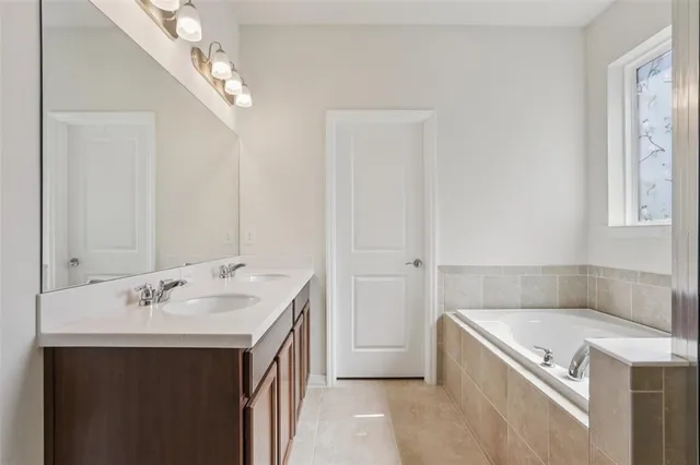 a bathroom with a tub sink and mirror