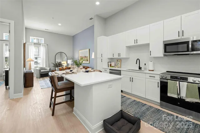 a kitchen with stainless steel appliances kitchen island granite countertop a sink and cabinets