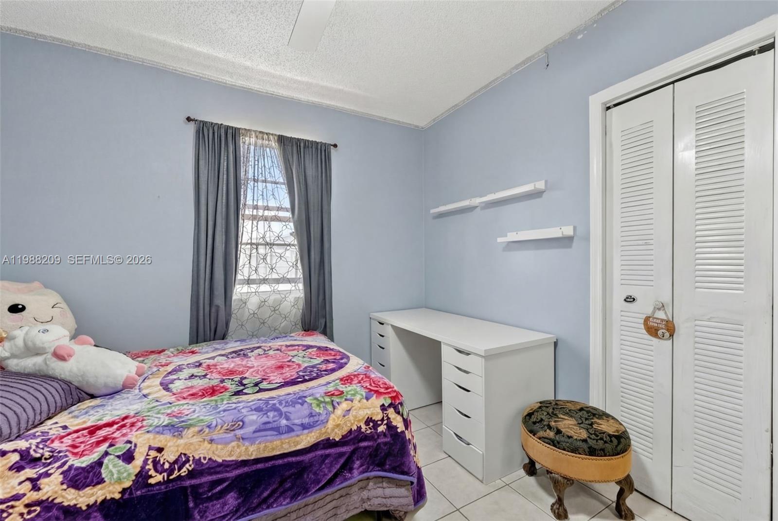 26672 Southwest 137th Court Homestead, FL 33032 - Photo 16 of 34 a bedroom with a bed and a chandelier