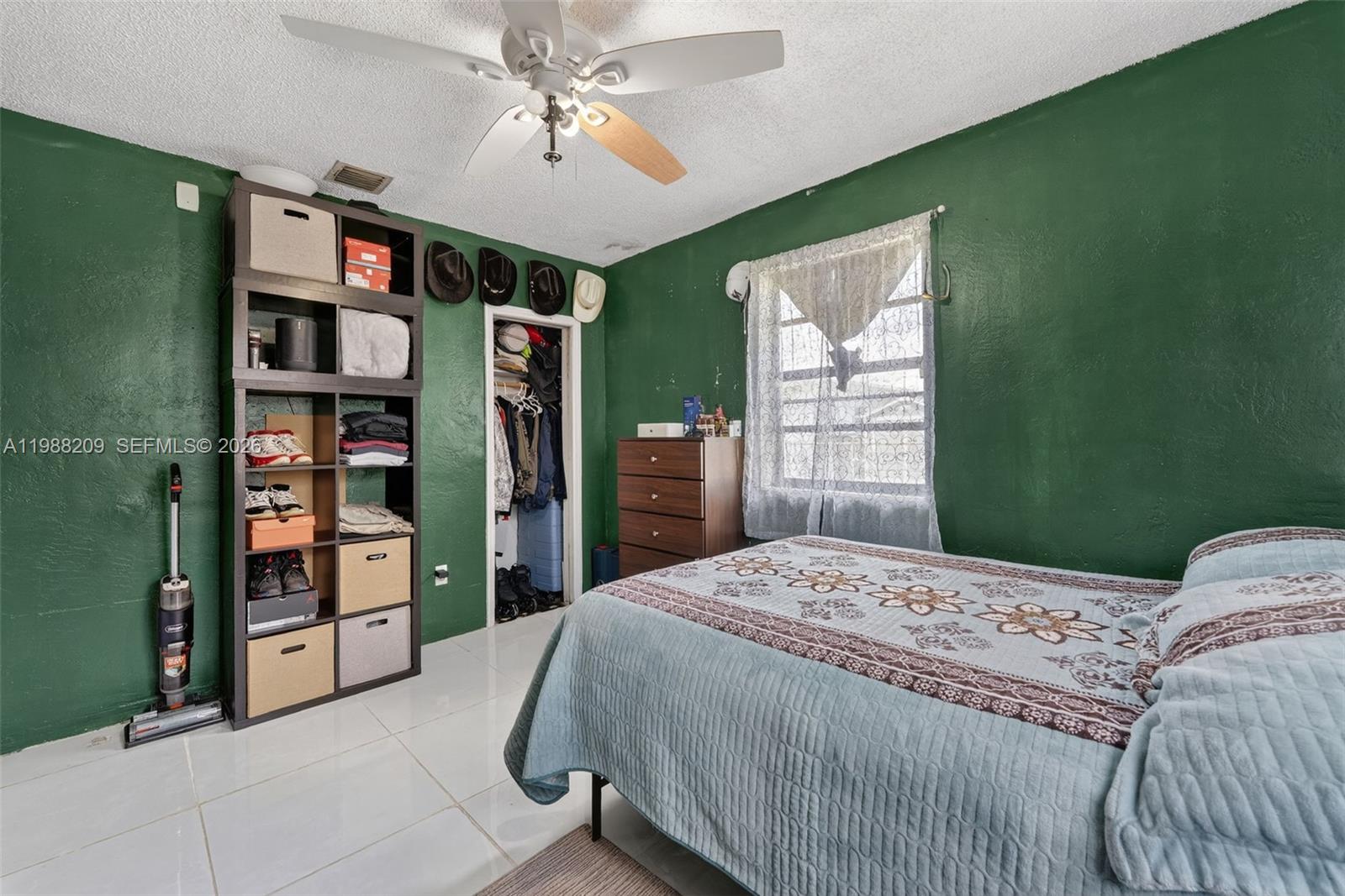 26672 Southwest 137th Court Homestead, FL 33032 - Photo 18 of 34 a bedroom with a large bed a chandelier and closet