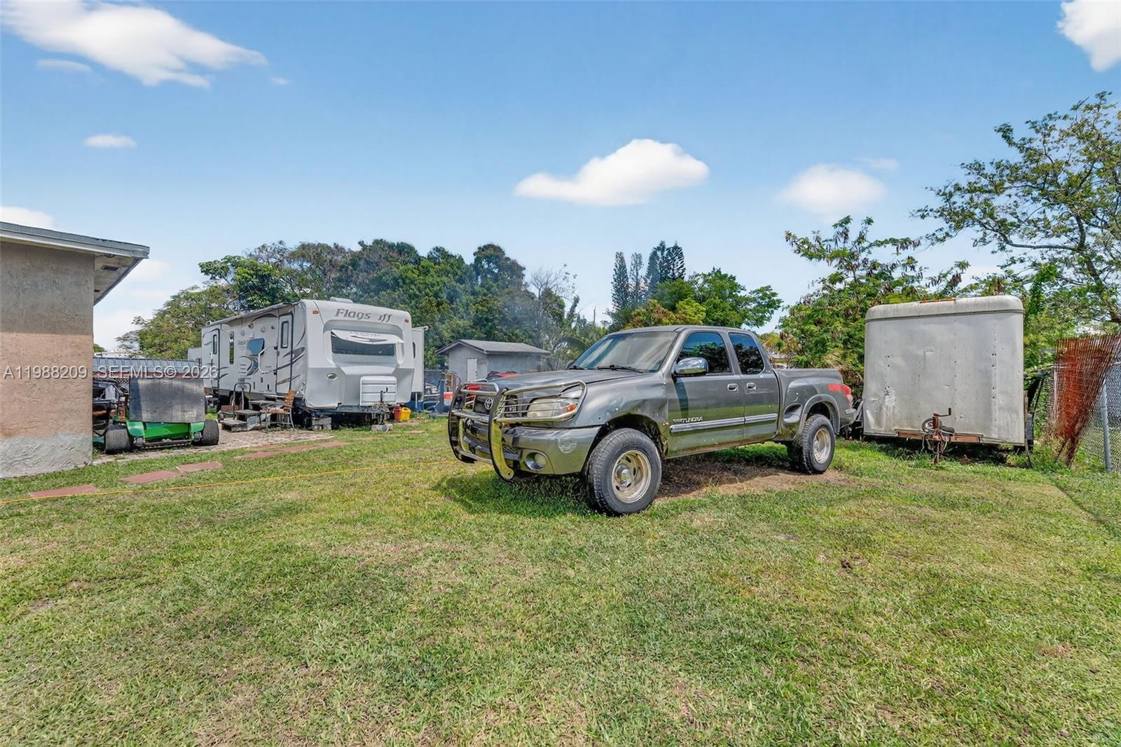 26672 Southwest 137th Court Homestead, FL 33032 - Photo 24 of 34 a view of a house with truck parked and a car parked in the yard