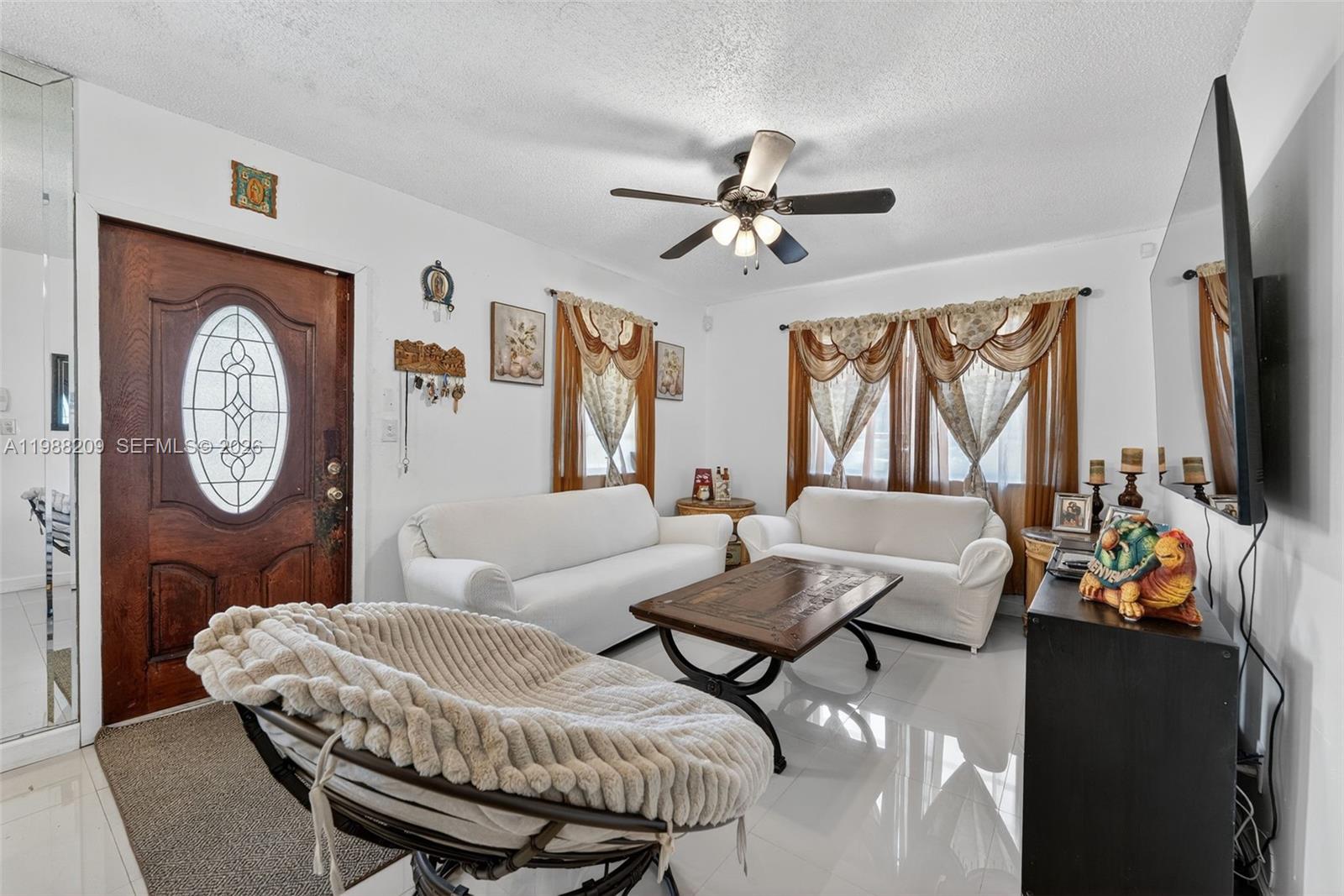 26672 Southwest 137th Court Homestead, FL 33032 - Photo 3 of 34 a living room with furniture a flat screen tv and a wall clock