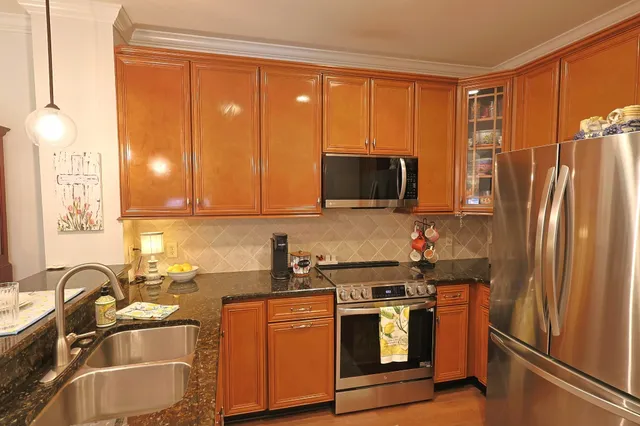 a kitchen with stainless steel appliances granite countertop a refrigerator stove and sink
