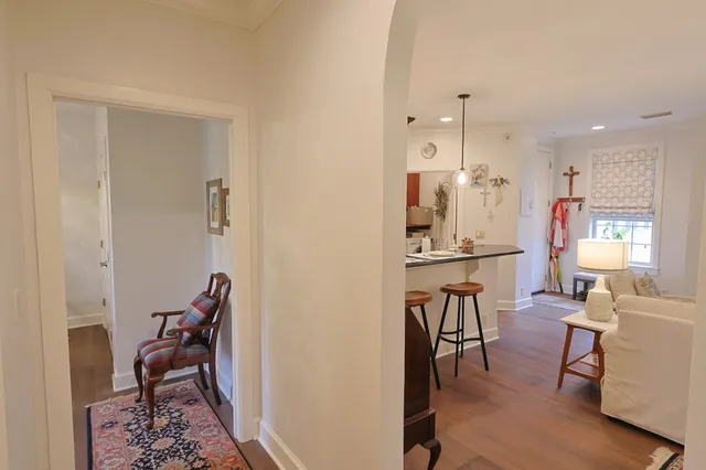 a view of a hallway with wooden floor and a bathroom