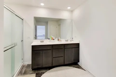 a bathroom with a double vanity sink a mirror and a shower