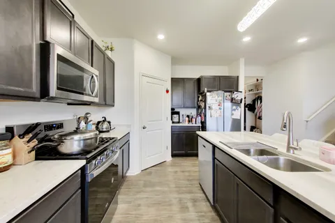 a kitchen that has a sink and a stove in it