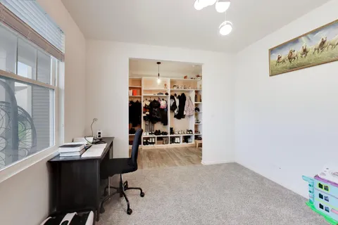a view of a workspace with furniture and a window