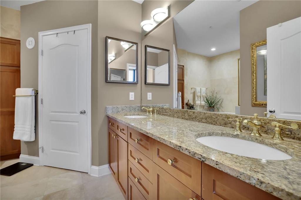 2828 Peachtree Road Northwest, Unit 1901 Atlanta, GA 30305 - Photo 18 of 35 a bathroom with a granite countertop sink and a mirror