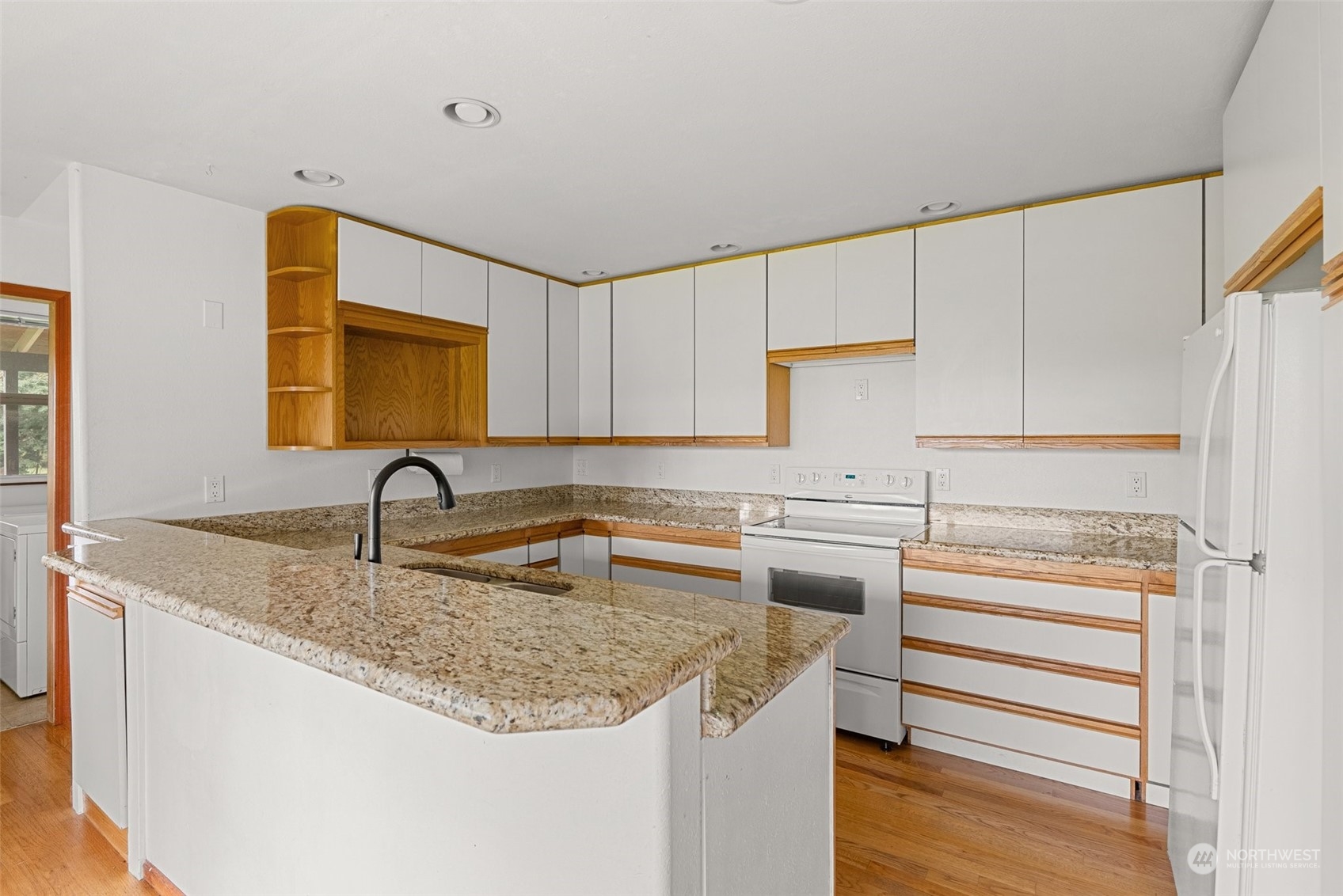 17 Maple Leaf Street Raymond, WA 98577 - Photo 7 of 27 a kitchen with stainless steel appliances granite countertop a sink and dishwasher a refrigerator with wooden cabinets