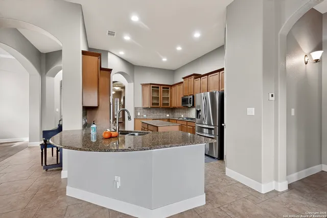 a kitchen with stainless steel appliances granite countertop a refrigerator and a sink