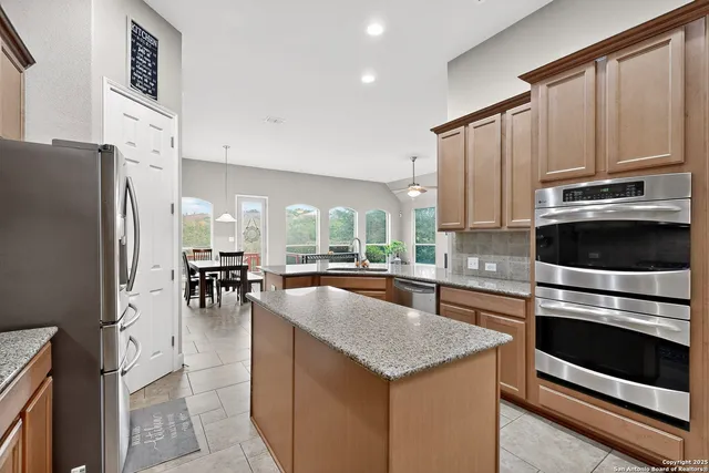 a kitchen with granite countertop a stove refrigerator and microwave