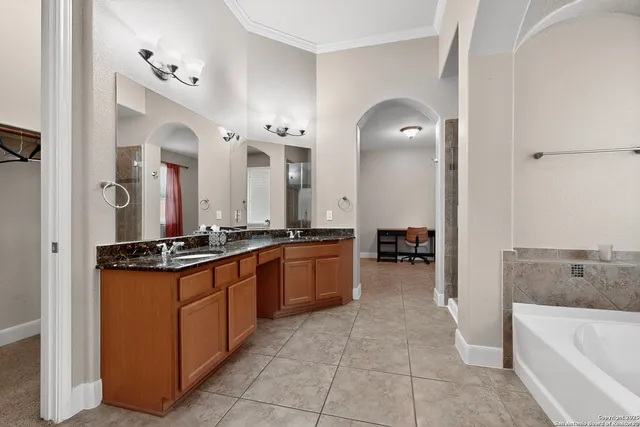 a large bathroom with a tub sink and mirror