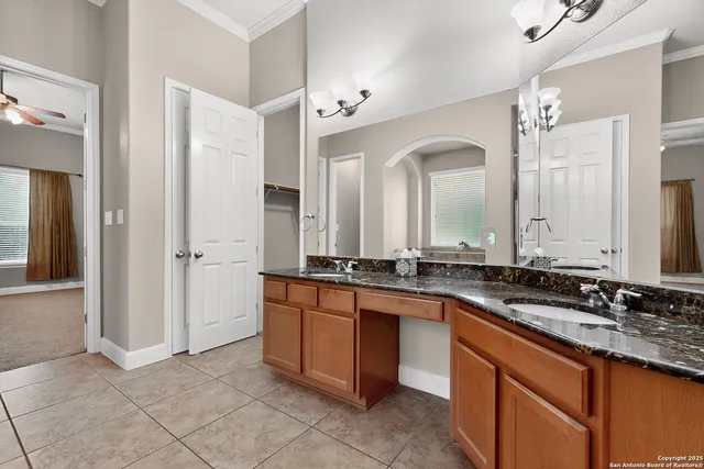 a bathroom with a granite countertop double vanity sink and a mirror