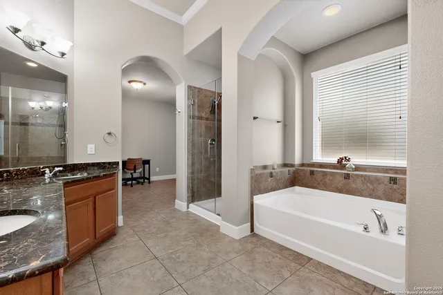 a large spacious bathroom with a tub a double vanity sink and a mirror