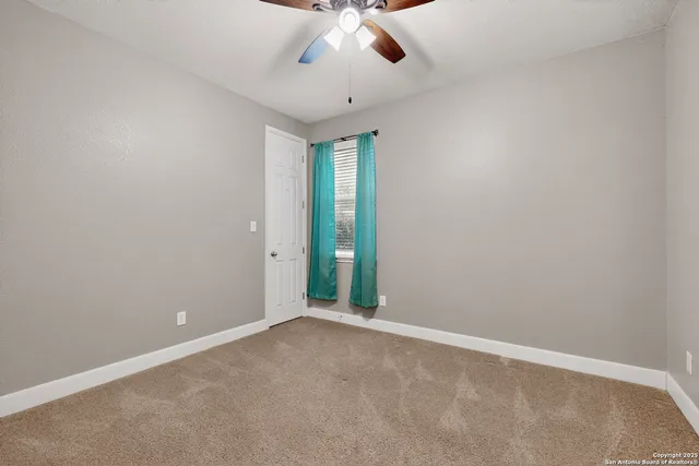 an empty room with chandelier fan