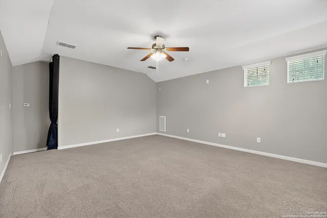 a view of a room with a ceiling fan and a window