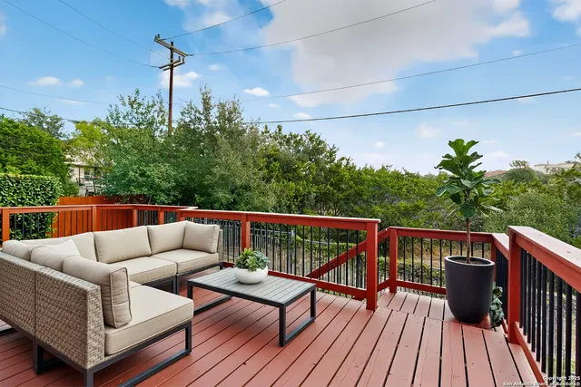 a balcony with wooden floor and outdoor seating