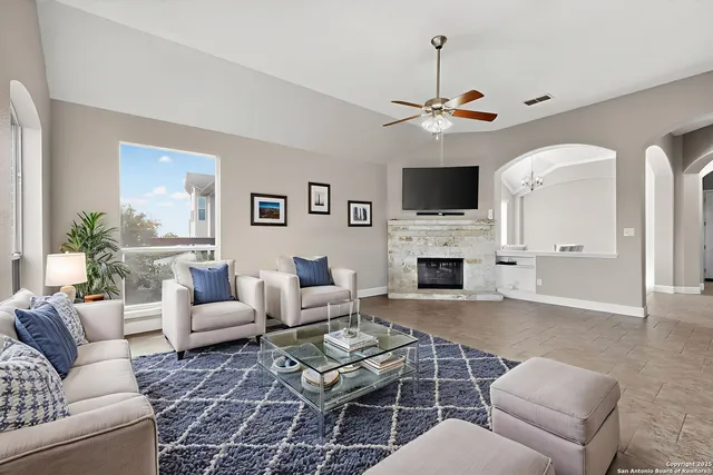 a living room with furniture a fireplace and a flat screen tv