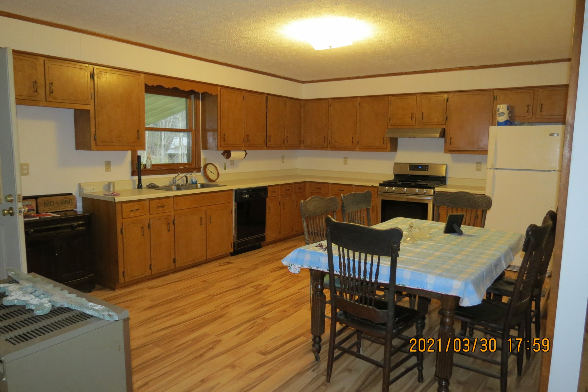 876 Denmark Road Erin, TN 37061 - Photo 17 of 45 a kitchen with stainless steel appliances granite countertop a stove a sink dishwasher a dining table and chairs with wooden floor