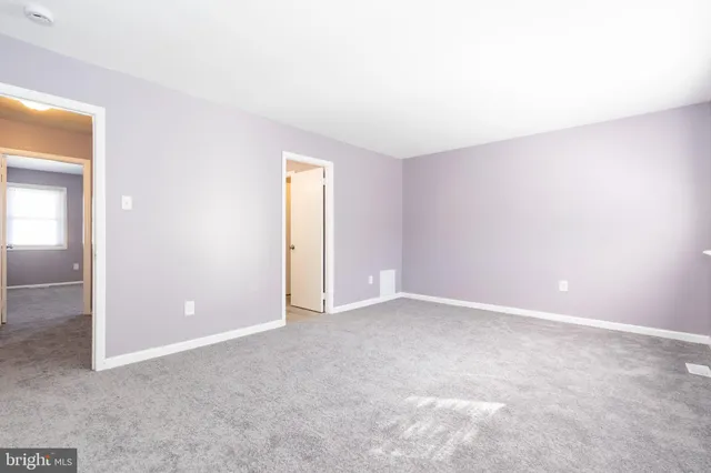 an empty room with closet and windows