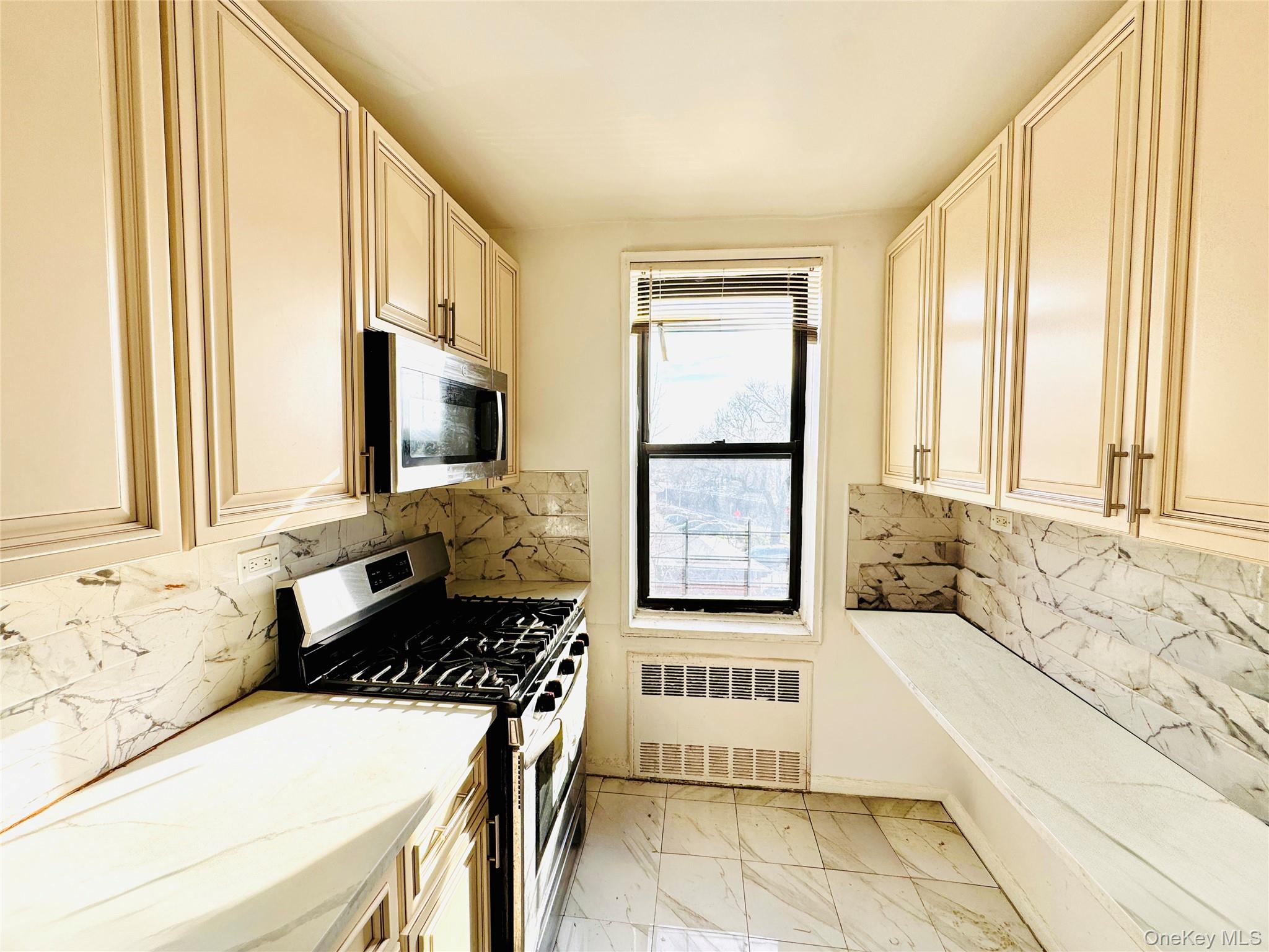 141-05 Pershing Crescent, Unit 207 Queens, NY 11435 - Photo 8 of 13 a kitchen with a stove a sink and a window