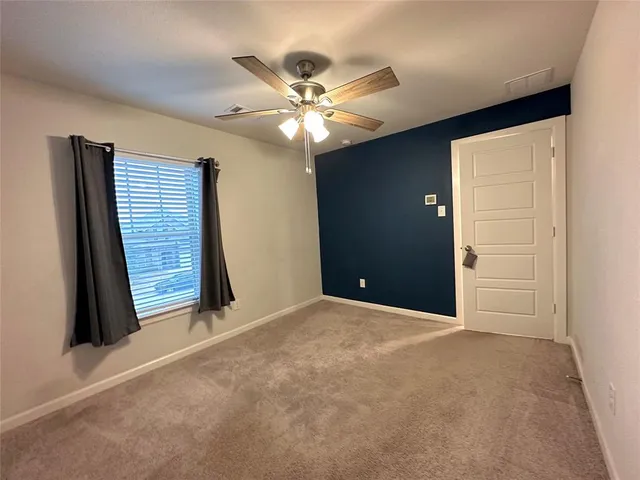 a view of an empty room with a ceiling fan