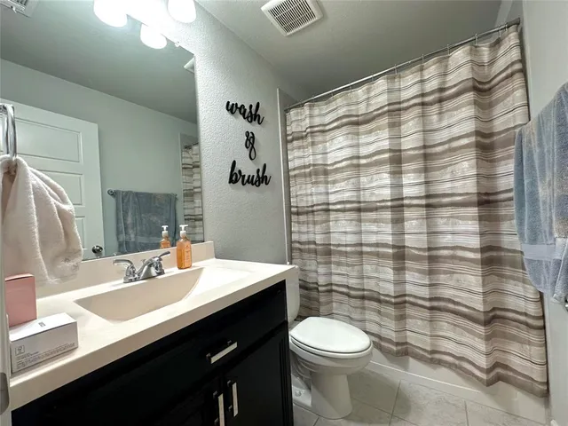 a bathroom with a sink a toilet and shower curtain