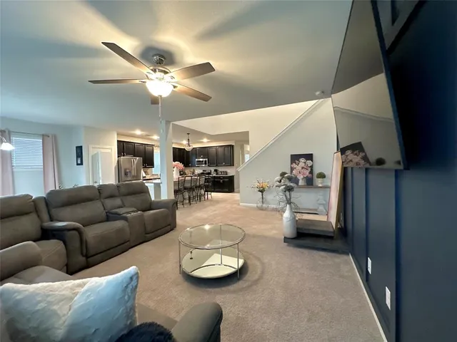 a living room with furniture and a view of kitchen