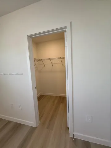 an empty room with wooden floor and door