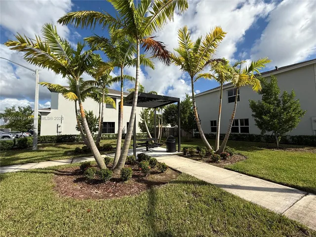 a view of a house with backyard and a tree