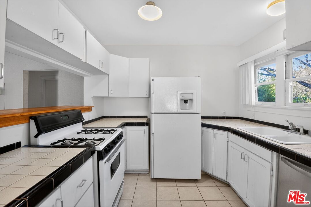 11029 Sarah Street Los Angeles, CA 91602 - Photo 11 of 27 a kitchen with a stove a sink and a refrigerator