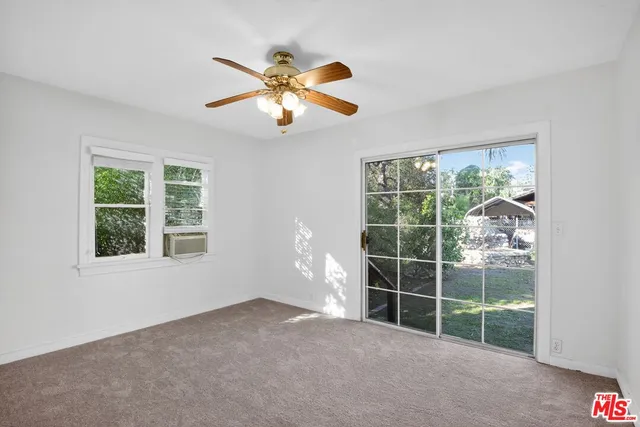 a view of a livingroom with a ceiling fan and window