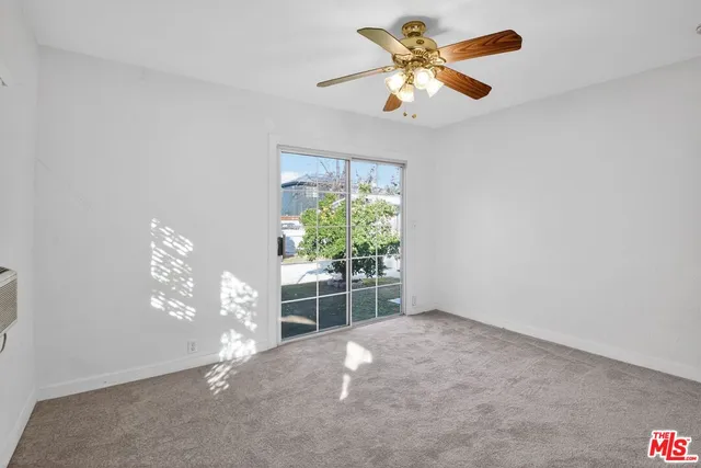 en empty room with windows and ceiling fan