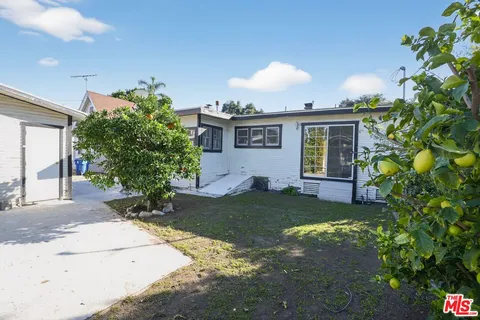 a front view of a house with a yard and potted plants