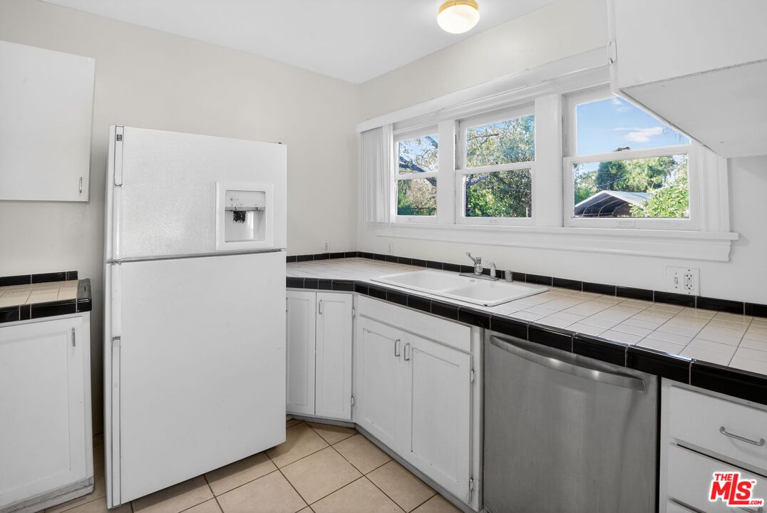 11029 Sarah Street Los Angeles, CA 91602 - Photo 10 of 27 a kitchen with a refrigerator and a sink