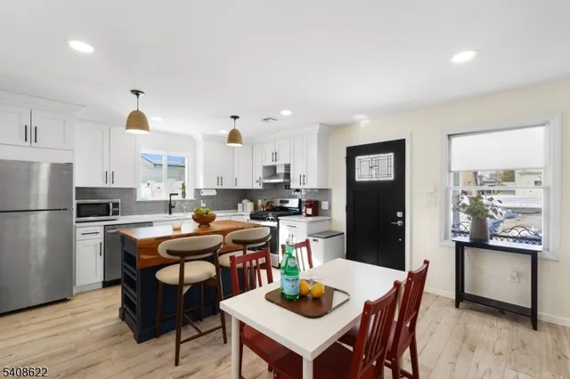 a kitchen with a dining table chairs and refrigerator
