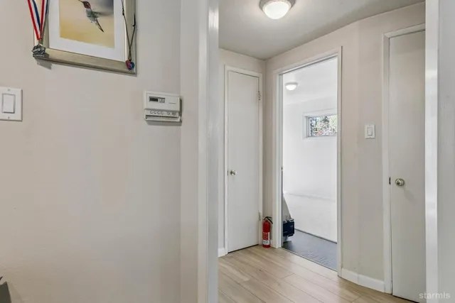 a view of a hallway with wooden floor and closet