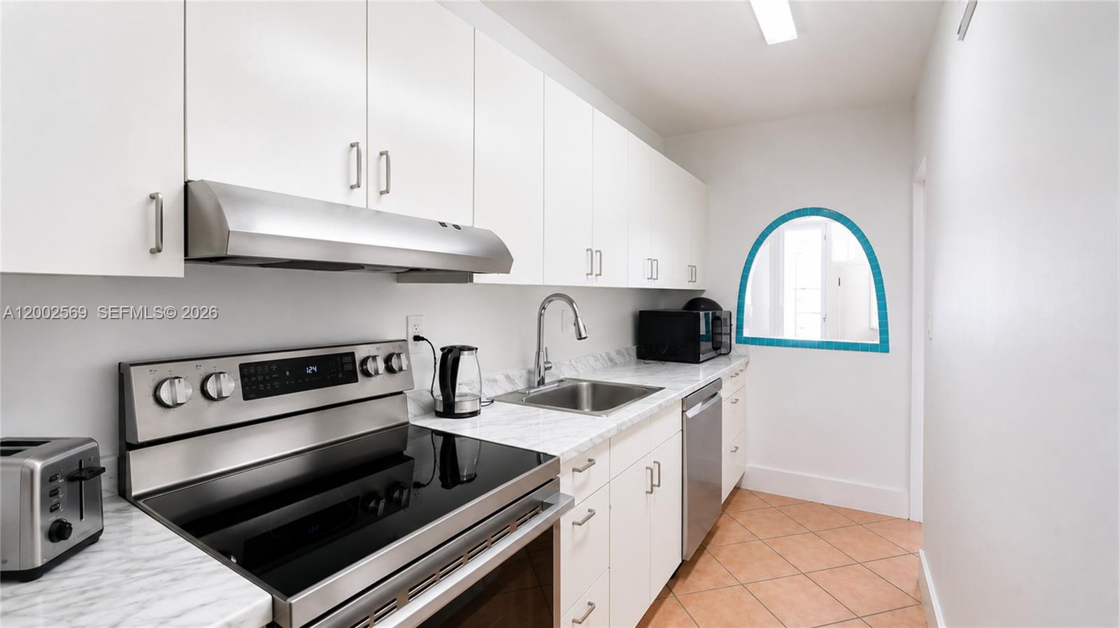 100 Lincoln Road, Unit 1209 Miami Beach, FL 33139 - Photo 6 of 25 a kitchen with stainless steel appliances a sink a stove and cabinets