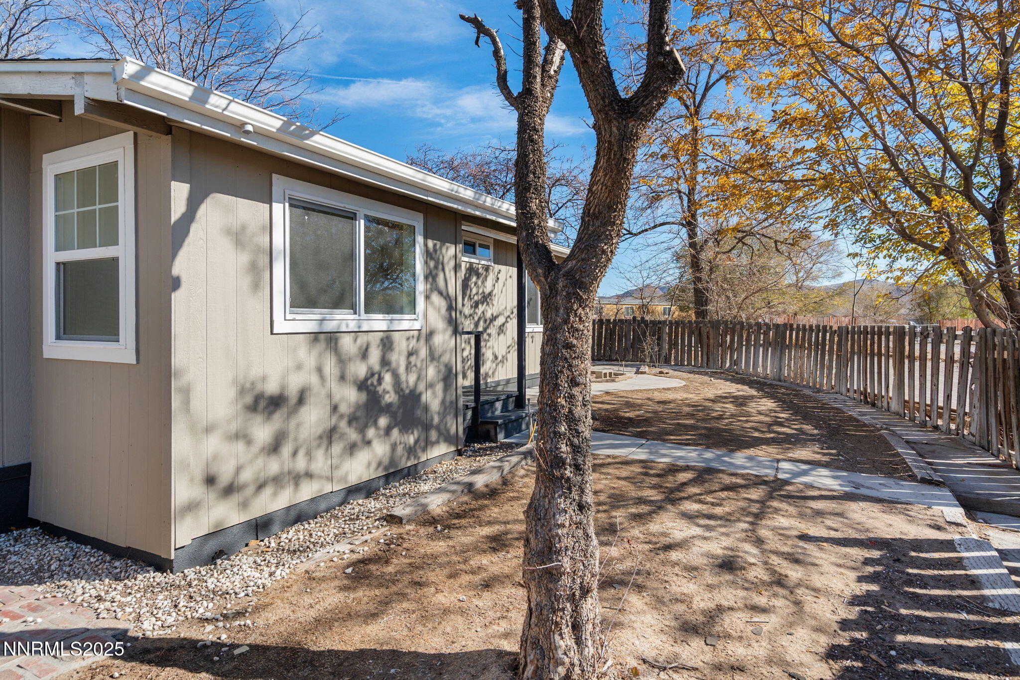 4925 Cheyenne Trail Silver Springs, NV 89429 - Photo 20 of 35 a backyard of a house with large trees and wooden fence