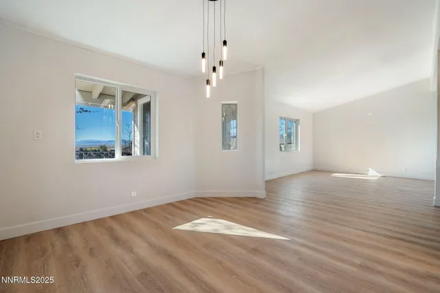 an empty room with wooden floor and window
