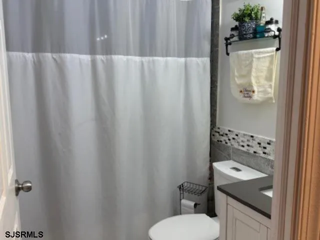 a bathroom with a sink and mirror with toilet