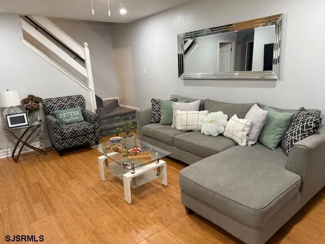 a living room with furniture and a wooden floor