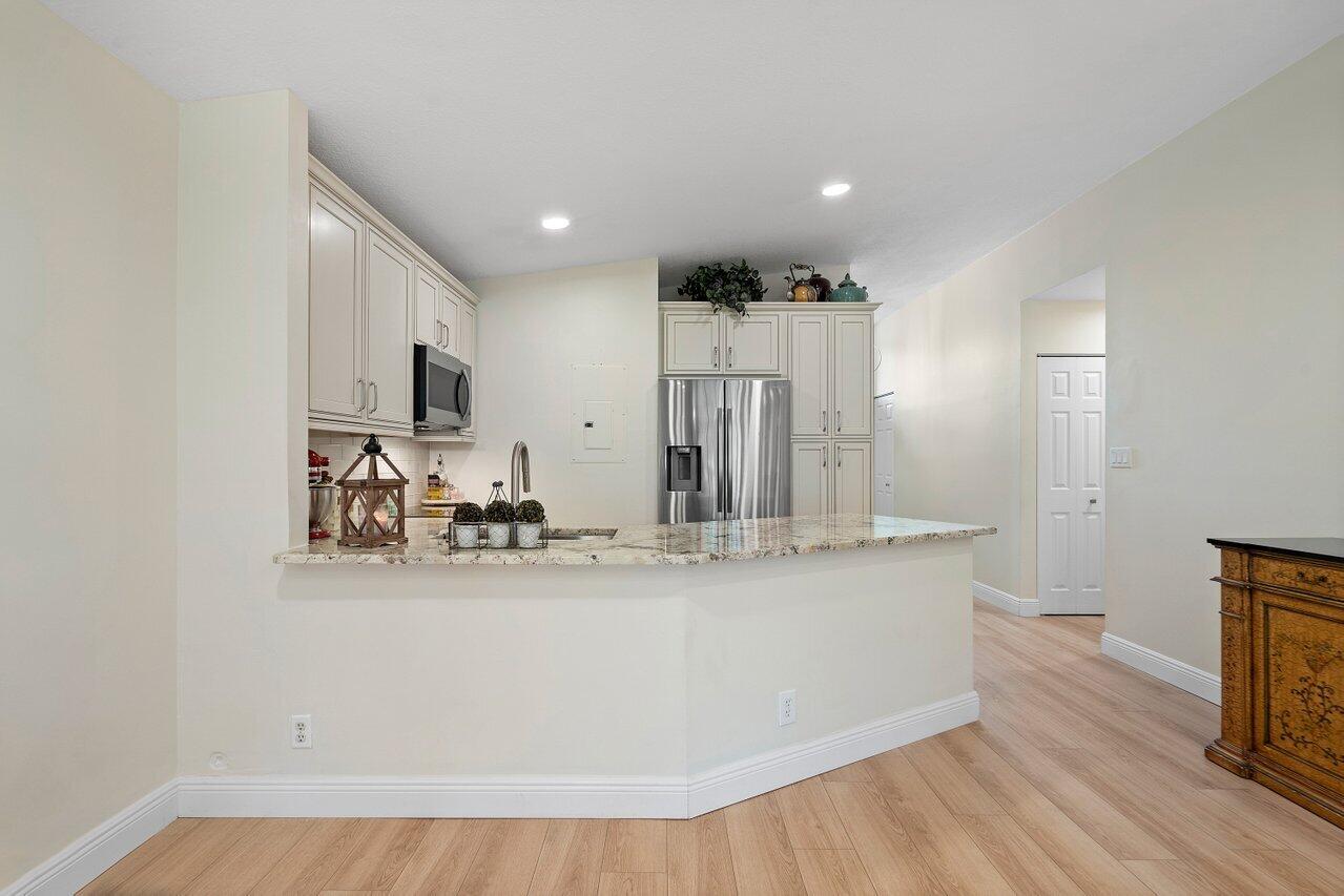 22543 Vistawood Way Boca Raton, FL 33428 - Photo 8 of 32 a view of a kitchen with kitchen island a sink wooden floor and counter top space