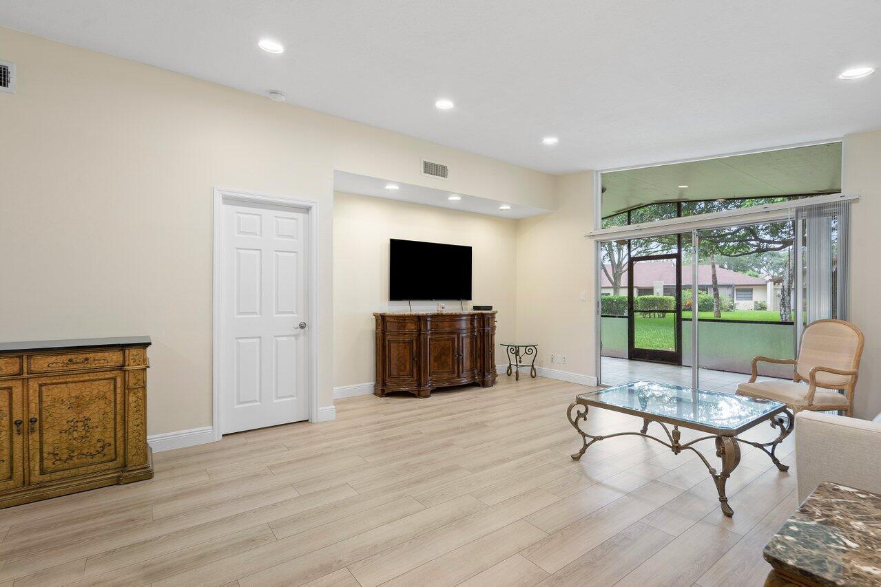 22543 Vistawood Way Boca Raton, FL 33428 - Photo 10 of 32 a living room with furniture a flat screen tv and a floor to ceiling window