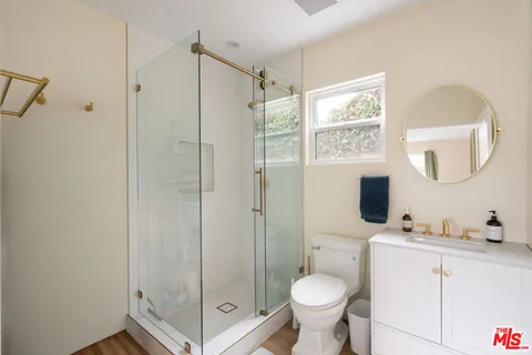 a bathroom with a shower sink mirror and toilet
