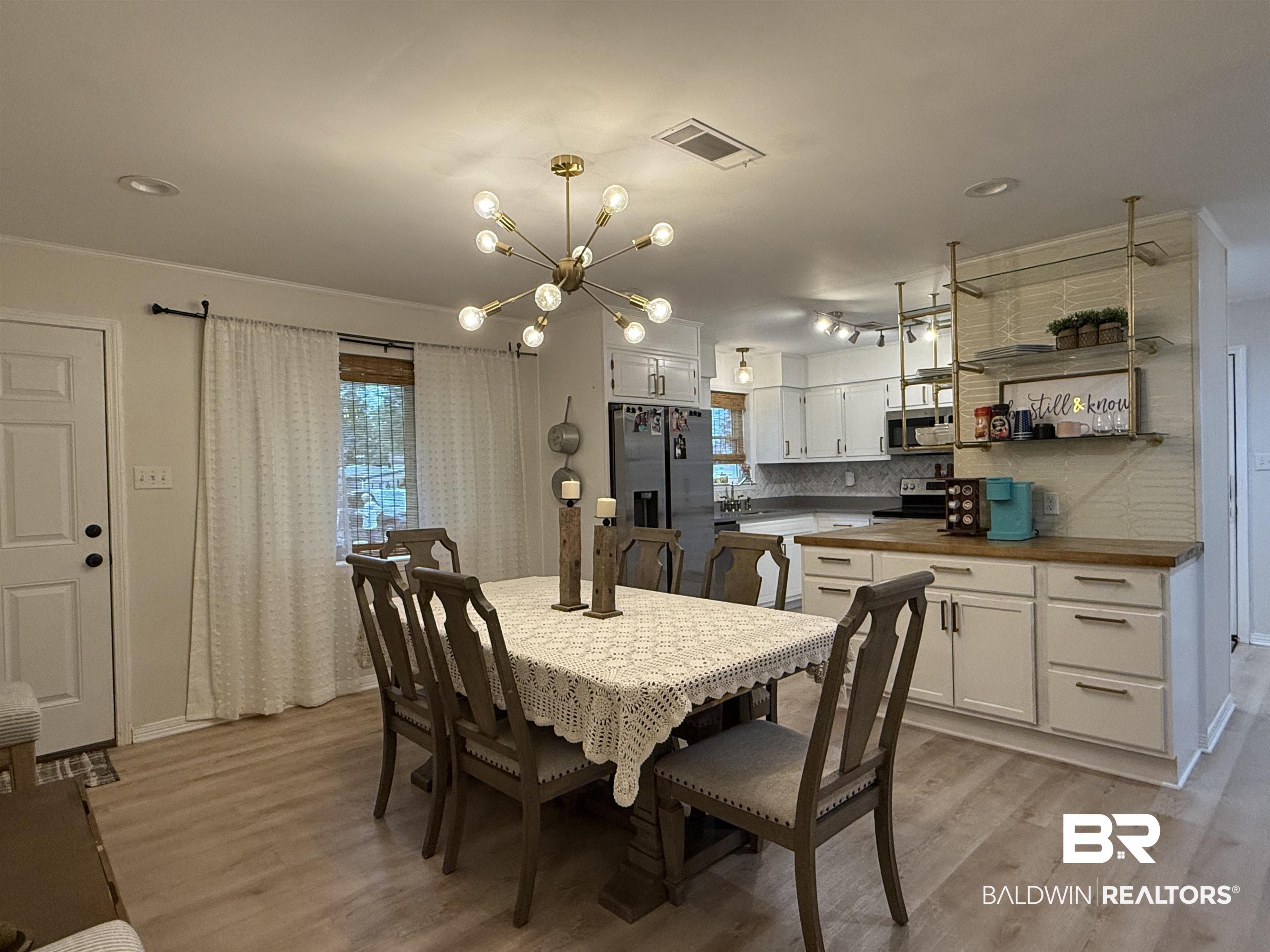 90 Florida Street Monroeville, AL 36460 - Photo 10 of 31 Dining area featuring a chandelier, and light wood-type flooring vinyl plank flooring