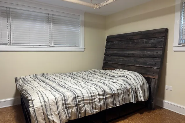 a bed sitting in a bedroom next to a window